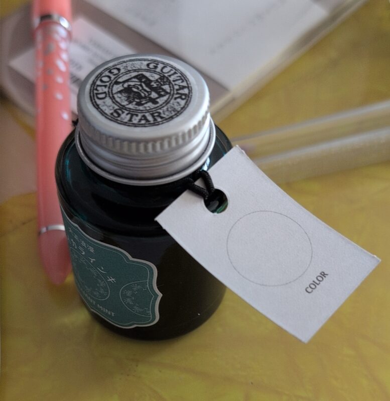Teranishi Guitar Brilliant Mint Ink showcasing the swatch spot on the tag that is attached to the mouth of the bottle.
