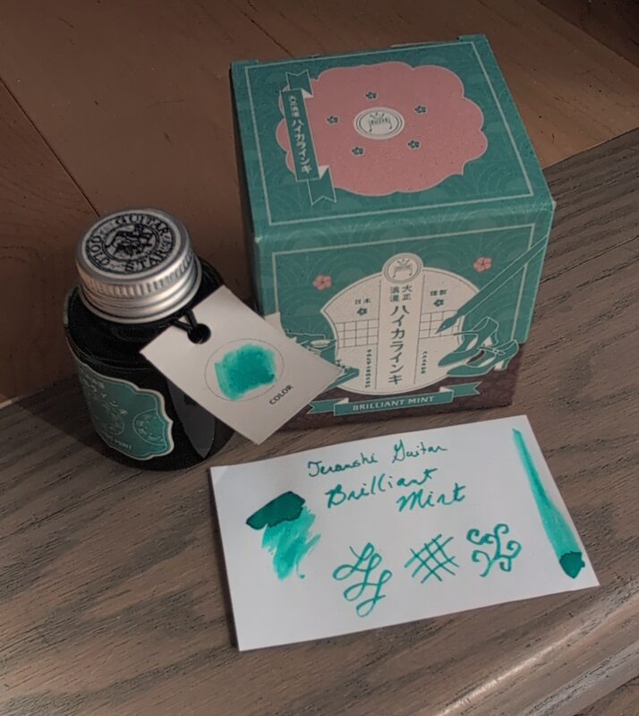 Teranishi Guitar Brilliant Mint Ink bottle, box and swatch. It's a medium teal fountain pen ink that leans a bit greenish (minty).