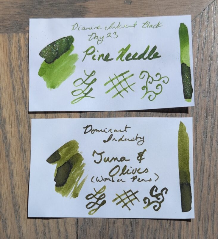 A comparison of two green fountain pen ink swatches: Diamine Pine Needle on top has green himmer and is a brighter new leaf green with shading, Dominant Industries Tuna & Olives is an olive ink with shading. 