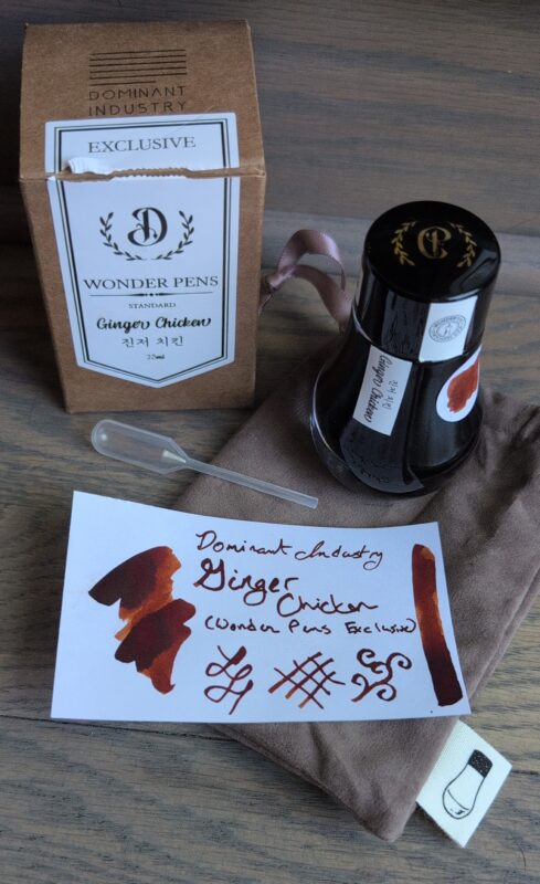 Dominant Industry Ginger Chicken, a Wonder Pens exclusive ink inspired by their orange cat. It's a deep orange/brown colour with nice shading. I've pictured the swatch with the packaging: the bottle with a nice wider round base, suede-like bag, pipette and cardboard box.