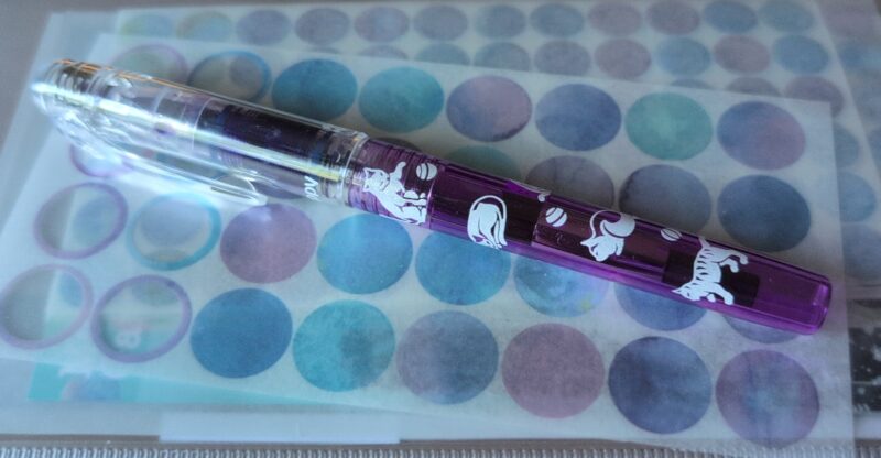 Platinum Preppy Wa purple pen with cats on it.  It's sitting on a clear case containing blue and purple washi dots.